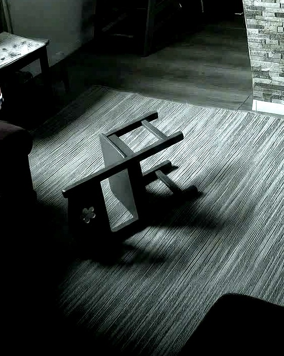 Der Kinderstuhl liegt auf der Seite auf dem Teppich.